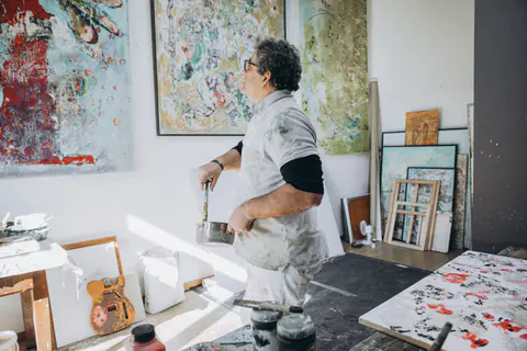 Maler arbeitet im Atelier an einer Leinwand